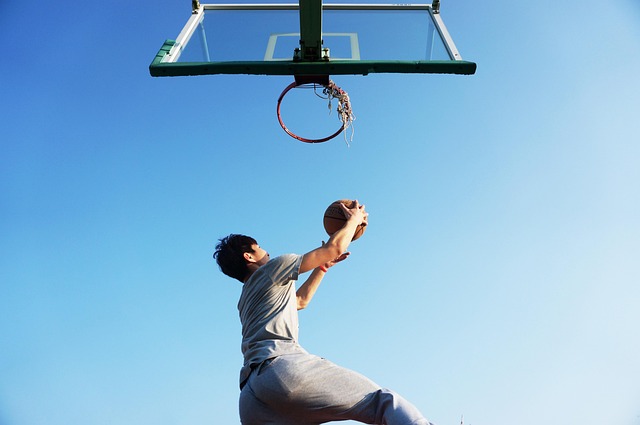 Basketball player mid-game executing a powerful dunk during a championship